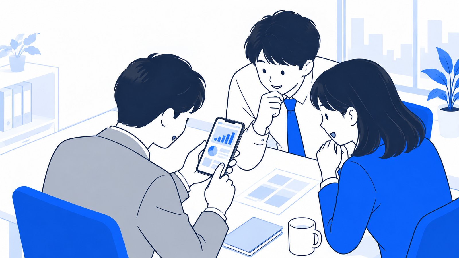 机の上のスマホアプリの画面を手に取って、成果を確かめるチームの会社員