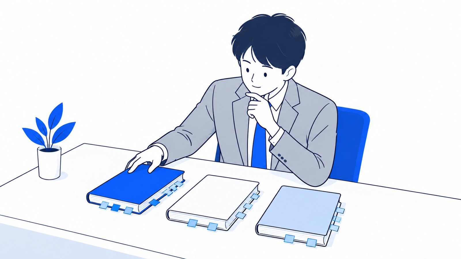 付箋の貼られた3冊の本を机に並べて、読む順番を決めている会社員