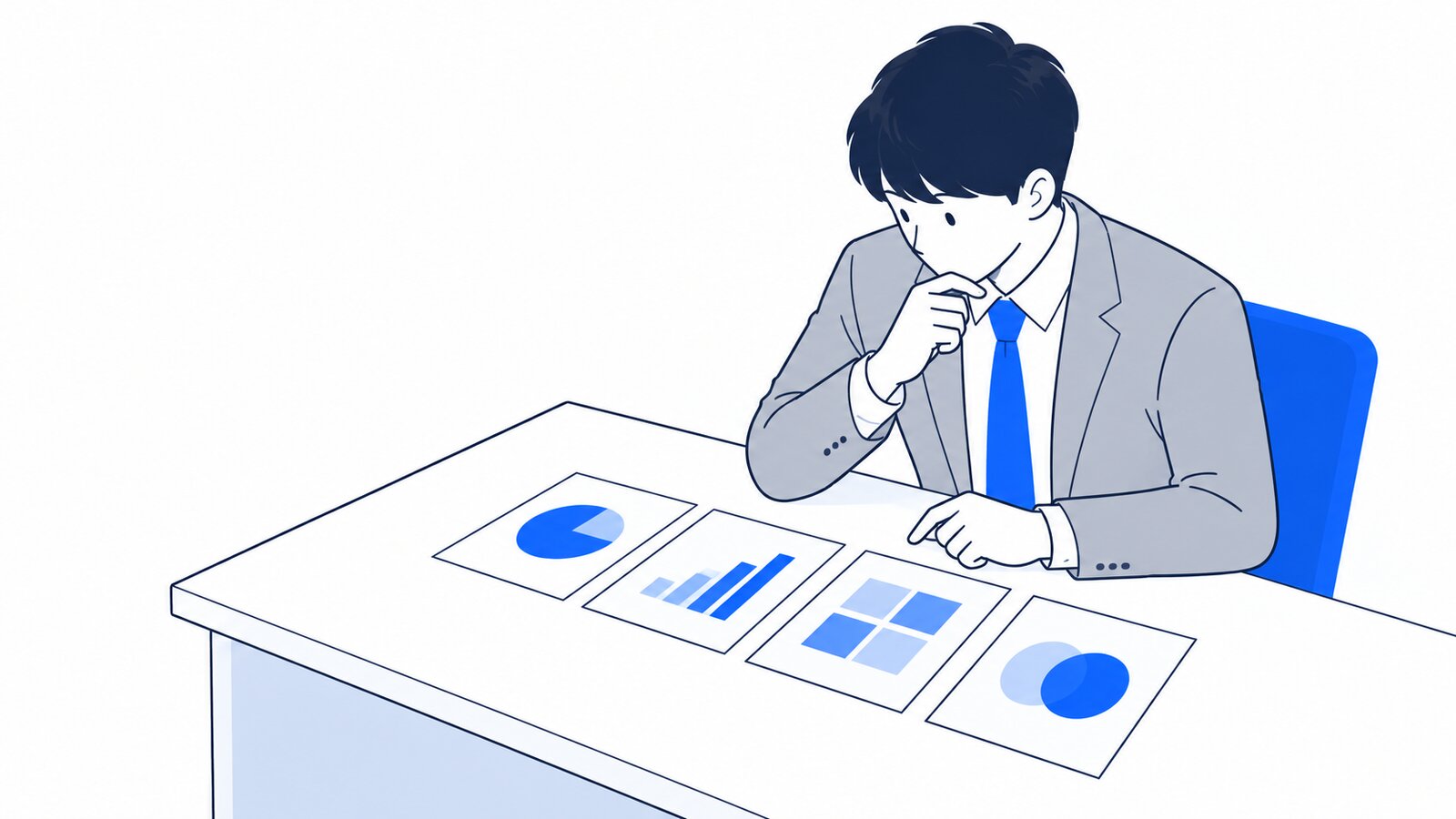 机の上に4枚のカードを並べ、違いを見比べて考える会社員